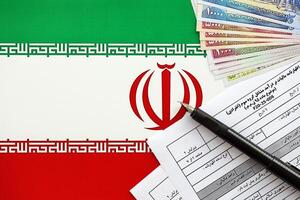 iranisch jährlich Einkommen MwSt Rückkehr bilden f20-25-006 bereit zu füllen auf Tabelle mit Stift und iranisch Geld auf Flagge foto