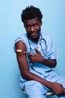 afroamerikanische Krankenschwester, die auf einen Impfverband zeigt foto