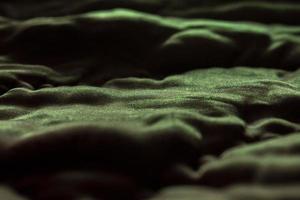 glänzende Stoffstruktur mit Schatten. abstrakte grüne Tapete. foto