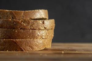 Stücke von Schwarzbrot Nahaufnahme auf einem Holzbrett. hausgemachtes Weizenbrot foto