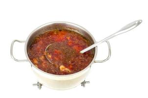 Topf mit Gemüse-Rote-Bete-Suppe auf weißem Hintergrund. foto