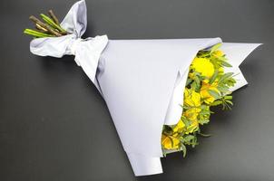 Strauß gelber Rosen in Kraftpapier. Foto