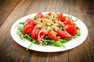 Salat mit Tomaten, Champignons, Rucola und Sonnenblumenkernen foto