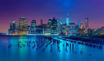 New York City bei Nacht. Manhattan-Skyline. Wolkenkratzer spiegeln sich im Wasser. ny, usa foto