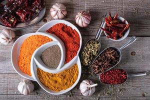 Vielzahl von Gewürzen und Kräutern in exotischen indischen Farben, auf dem Küchentisch foto