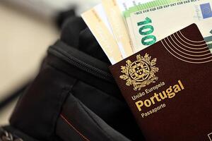 rot Portugal Reisepass von europäisch Union mit Geld und Fluggesellschaft Tickets auf touristisch Rucksack foto