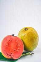 Guave isoliert. Sammlung von rot fleischig Guave Obst mit gelblich Grün Haut auf ein Blatt isoliert auf ein Weiß Hintergrund. foto