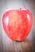 roter Apfel auf holzigem Hintergrund foto