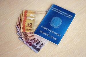 Brasilianer Arbeit Karte und Sozial Sicherheit Blau Buch und reais Geld Rechnungen foto
