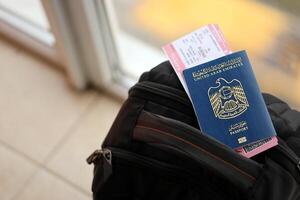 Blau vereinigt arabisch Emirate Reisepass mit Fluggesellschaft Tickets auf touristisch Rucksack foto