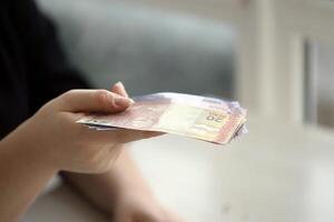 Brasilianer Geld Rechnungen im Frau Hand. weiblich gibt Bündel von Brasilianer reais zu uns foto