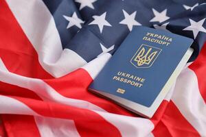 ukrainisch biometrisch Reisepass auf gefaltet winken Flagge von vereinigt Zustände von Amerika foto