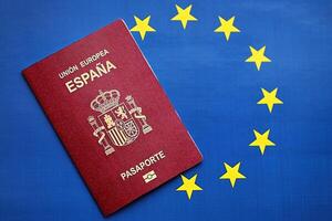 rot Spanisch Reisepass von europäisch Union auf Blau Flagge Hintergrund schließen oben foto