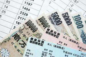 Licht Blau und rot Japan Gesundheit Versicherung Karten auf Tabelle mit japanisch Yen Geld foto