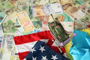 Spielzeug Panzer auf uns Flagge und ukrainisch Flagge auf viele Banknoten von anders Währung foto
