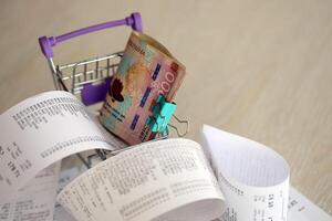 ukrainisch Griwna Geld Rechnungen Bündel im Einkaufen Wagen umgeben durch viele Papier Quittungen foto