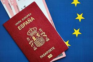 rot Spanisch Reisepass von europäisch Union mit Fluggesellschaft Tickets auf Blau Hintergrund schließen oben foto