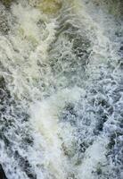 Wasserwellen des Flusses und des Meeres treffen bei Flut und Ebbe aufeinander. Tiefblaue stürmische Meerwasseroberfläche mit weißem Schaum und Wellenmuster, Hintergrundfoto foto