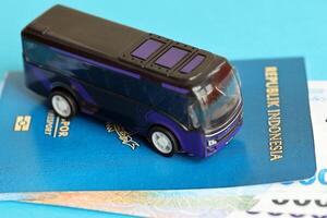 Blau Republik Indonesien Reisepass mit Geld und Spielzeug Bus auf Blau Hintergrund schließen oben foto