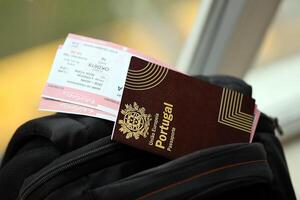 rot Portugal Reisepass von europäisch Union mit Fluggesellschaft Tickets auf touristisch Rucksack foto