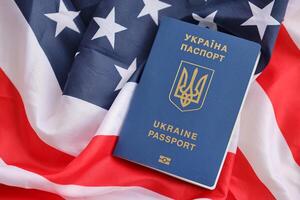 ukrainisch biometrisch Reisepass auf gefaltet winken Flagge von vereinigt Zustände von Amerika foto
