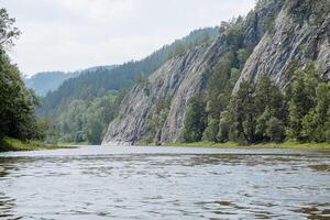 das Wasser Oberfläche auf das wild Taiga Fluss, das Panorama von das Berg Fluss, das schier Klippen in der Nähe von das Wasser, das Natur Reservieren, das heiß Tag, das schön Landschaft, das Berge und das Wald. foto