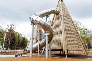 Pyramide rutschen gemacht von Holz, Spiral- Tube gleiten, Metall Struktur, abspielen mit Kinder, Spielplatz, draussen abspielen Raum. foto