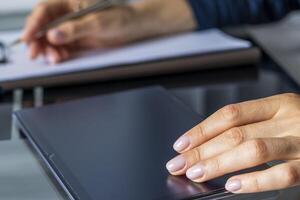 schließen oben Schuss von das Frau mit schön Hände im das Geschäft Kleidung, Arbeiten auf das Tablette im das Büro, Herstellung Anmerkungen. städtisch foto