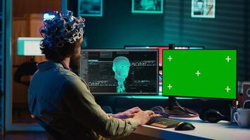 Entwickler mit eeg Headset, beginnend Verstand hochladen Prozess mit isoliert Bildschirm Schreibtisch. Mann mit neurowissenschaftlich Gerät zu Transfer Bewusstsein in Cyberspace mit Chroma Schlüssel Monitore, Kamera ein foto