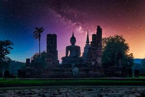 milchig Weg Über groß Buddha beim Nacht im wat Mahathat Tempel, Sukhothai historisch Park, Thailand. foto