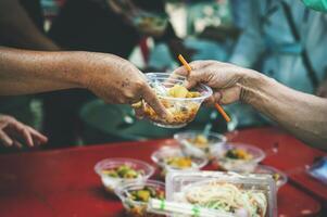 Freiwillige Portion Essen zu das obdachlos im das Gemeinschaft wohltätig Spende Center Konzept von kostenlos Essen Hilfe Bedienung foto