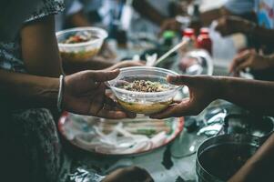 Freiwillige sind geben kostenlos Essen zu Hilfe das hungrig Arm Konzept von Essen Teilen foto