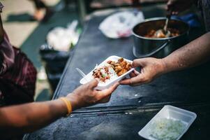 geben Essen zu Bettler zu Hilfe reduzieren Hunger mit Anliegen. Konzepte von Essen Spenden und Hilfe foto