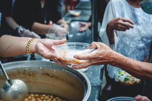 das Hände von Bettler erhalten gespendet Lebensmittel. Konzept von Nächstenliebe Essen zum das Arm foto