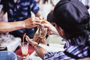 Fütterung Konzepte . Hand angeboten zu spenden Essen von ein Reich Mann Aktie. das Konzept von Sozial Teilen . Arm Menschen Empfang Essen von Spenden foto