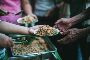 Freiwillige sind geben kostenlos Essen zu Hilfe das hungrig Arm Konzept von Essen Teilen foto