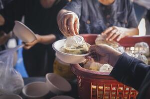 Freiwillige Portion heiß Mahlzeiten zu hungrig Migranten humanitär Hilfe Konzept. foto