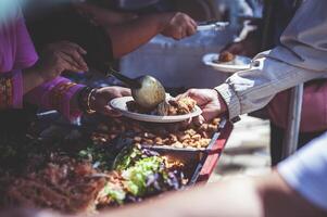 Freiwillige Portion heiß Mahlzeiten zu hungrig Migranten humanitär Hilfe Konzept. foto