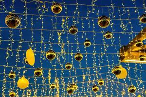 Neu Jahr oder Weihnachten festlich golden Bälle hängend im Reihen gegen das Nacht Himmel. foto