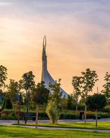 Usbekistan, Taschkent - - September 15, 2023 Monument von Unabhängigkeit im das bilden von ein Stele mit ein Humo Vogel auf ein Dämmerung mit dramatisch Klötze im das Neu Usbekistan Park. foto