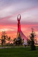 Usbekistan, Taschkent - - September 15, 2023 Monument von Unabhängigkeit im das bilden von ein Stele mit ein Humo Vogel auf ein Dämmerung mit dramatisch Klötze im das Neu Usbekistan Park. foto