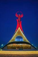 Usbekistan, Taschkent Januar 4, 2023 beleuchtet Monument von Unabhängigkeit im das bilden von ein Stele mit ein Humo Vogel im das Neu Usbekistan Park beim Nacht. foto