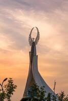 Usbekistan, Taschkent - - September 15, 2023 Monument von Unabhängigkeit im das bilden von ein Stele mit ein Humo Vogel auf ein Dämmerung mit dramatisch Klötze im das Neu Usbekistan Park. foto