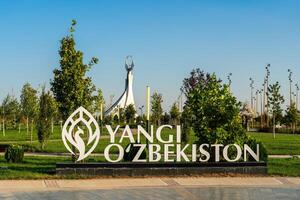 Usbekistan, Taschkent - - September 15, 2023 Inschrift yangi Usbekistan und Monument von Unabhängigkeit im das bilden von ein Stele mit ein Humo Vogel auf ein tagsüber im das Neu Usbekistan Park im Sommer. foto