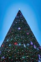 künstlich Weihnachten Baum im Girlanden beim Dämmerung. foto