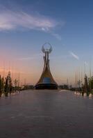 Usbekistan, Taschkent - - September 15, 2023 Monument von Unabhängigkeit im das bilden von ein Stele mit ein Humo Vogel auf ein Dämmerung mit dramatisch Klötze im das Neu Usbekistan Park. foto