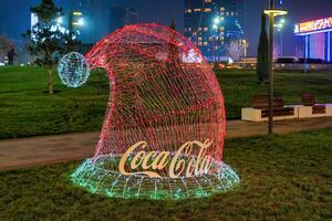 Usbekistan, Taschkent - - Dezember 27, 2022 das Coca Cola Unternehmen Logo auf ein Weihnachten Dekoration gemacht von Girlanden. foto