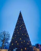 künstlich Weihnachten Baum im Girlanden beim Dämmerung. foto