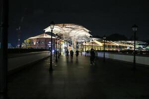 Singapur, 2024 - - Menschen Silhouette Kreuzung ein Brücke schließen zu clarke Kai foto