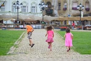 Timisoara, Rumänien - - Juli 24, 2013 - - wenig Kinder Laufen Nieder Backstein Straße. geeignet zum Kinder- Aktivitäten und draussen Abenteuer foto